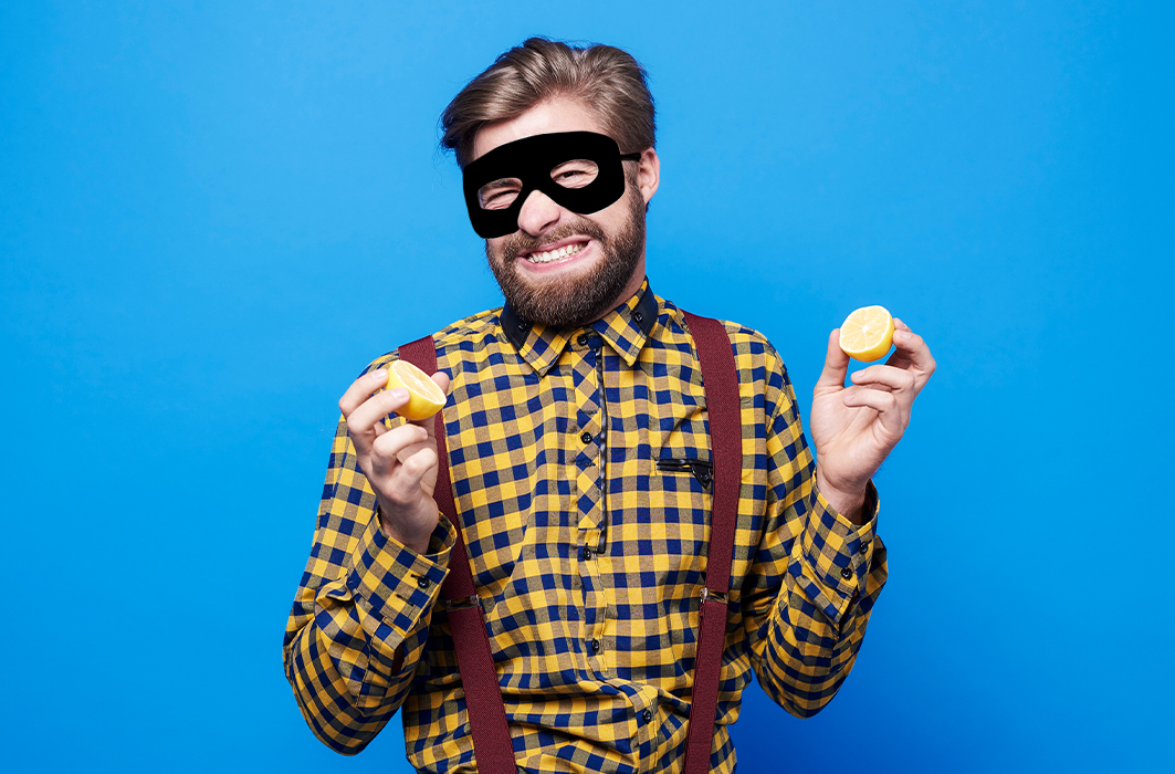 Un homme avec un masque de bandit et des citrons.