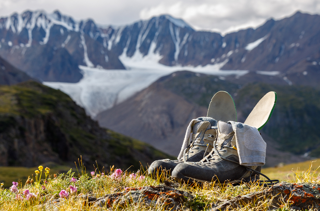 Des bottes de randonnées devant un paysage montagneux.