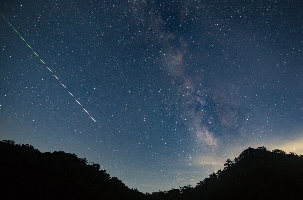 Un météore traverse le ciel étoilé.