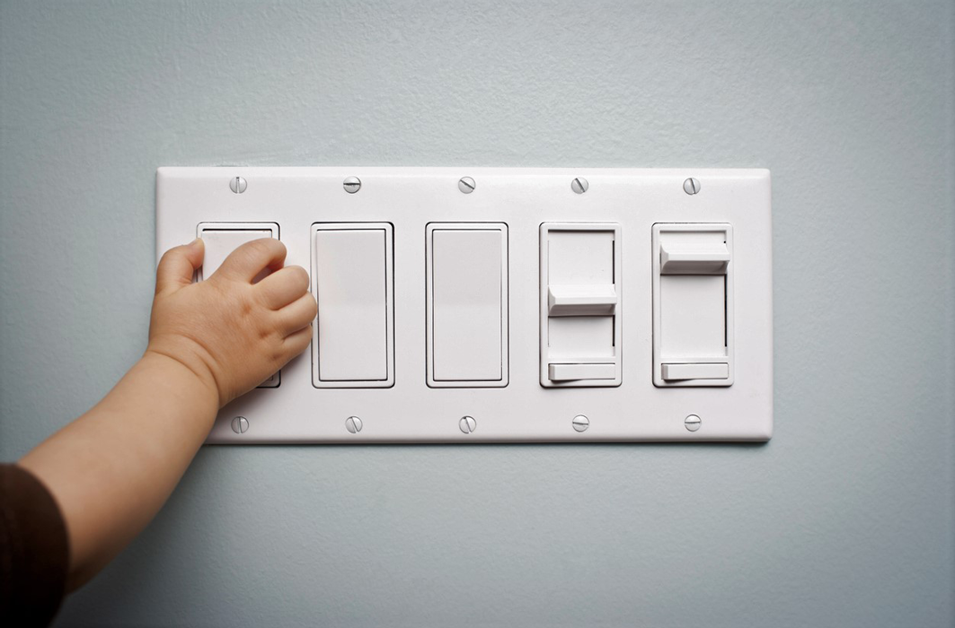 Un très jeune enfant éteint la lumière.