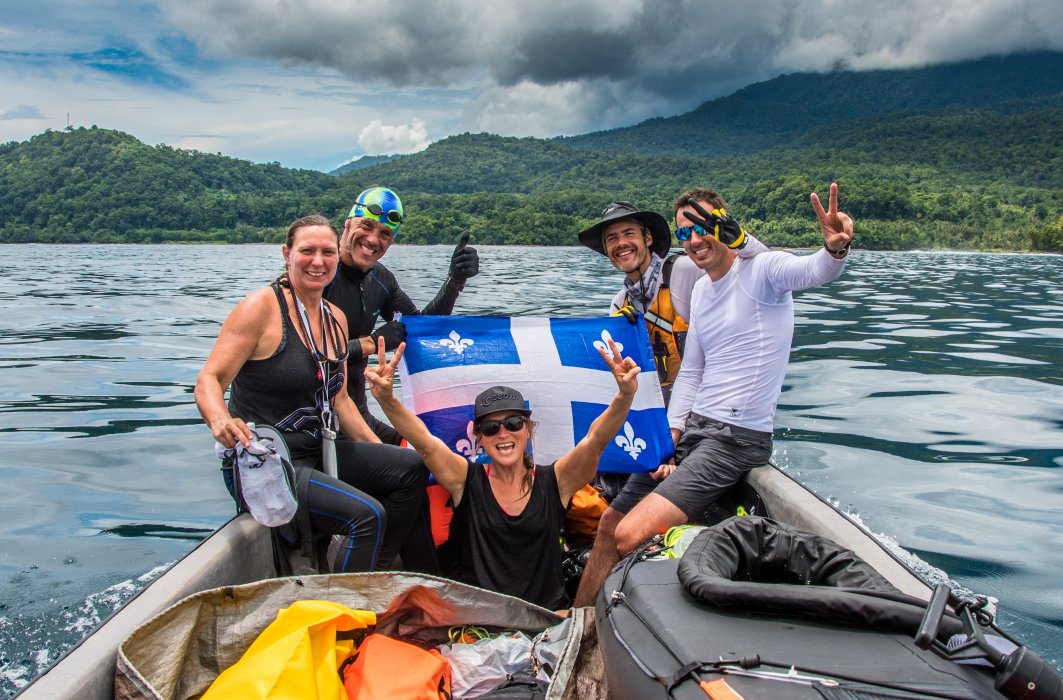 Quelques membres de l'équipe de Normand Jr Piché célèbrent sur un bateau avec un drapeau du Québec.