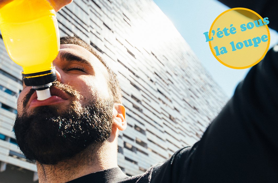 Un jeune homme s'hydrate avec une boisson colorée