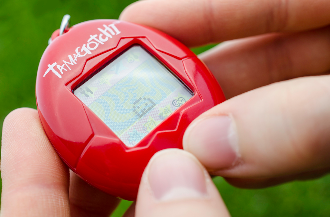 Un propriétaire de Tamagotchi s'amuse avec son animal de compagnie virtuel. Un propriétaire de Tamagotchi s'amuse avec son animal de compagnie virtuel.