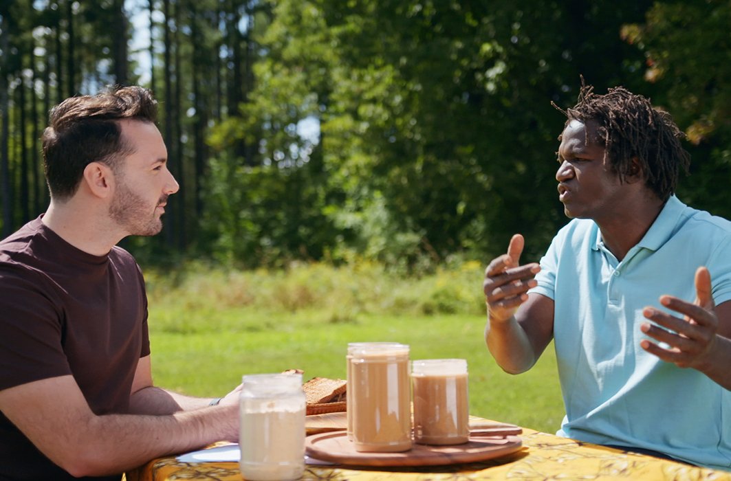 Boucar Diouf discute du beurre d'arachides avec un spécialiste de l'alimentation.