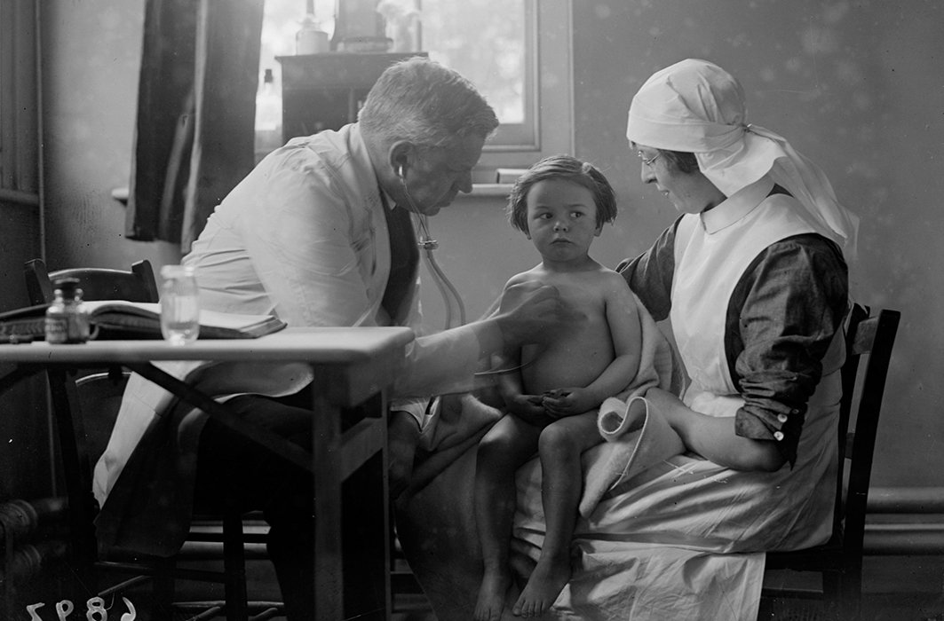 Un médecin examine un enfant dans les années 1920.