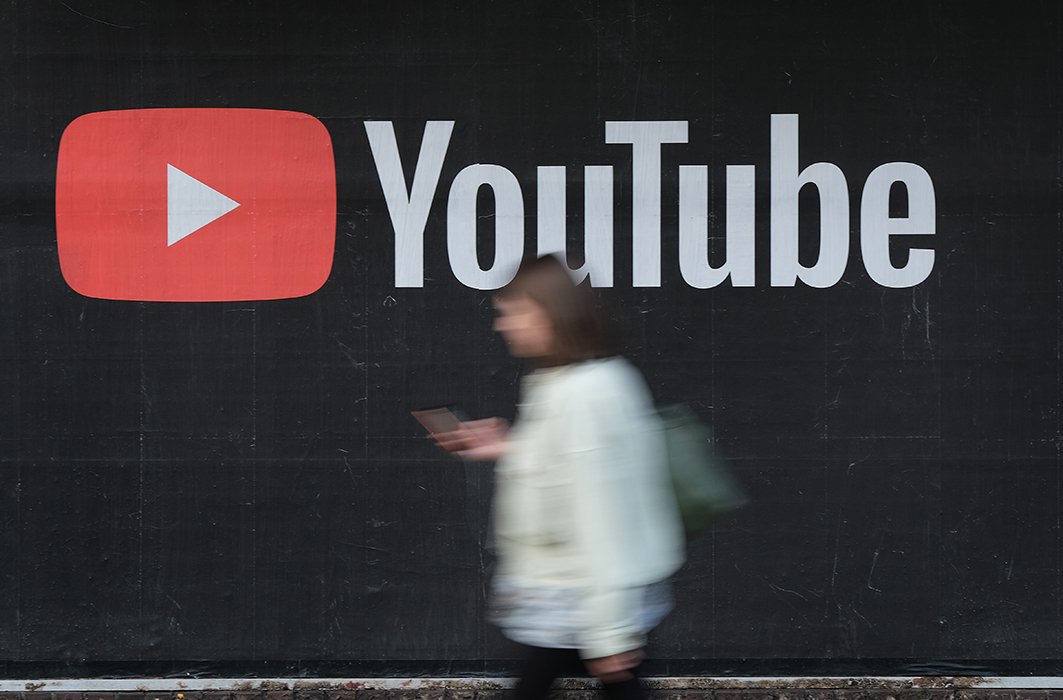 Une personne passe devant une publicité  de la plateforme YouTube.