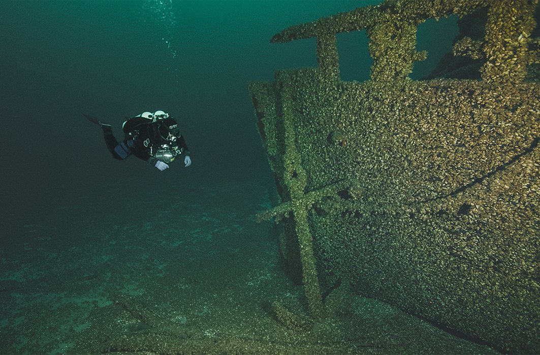Un plongeur examine l'épave d'un navire.