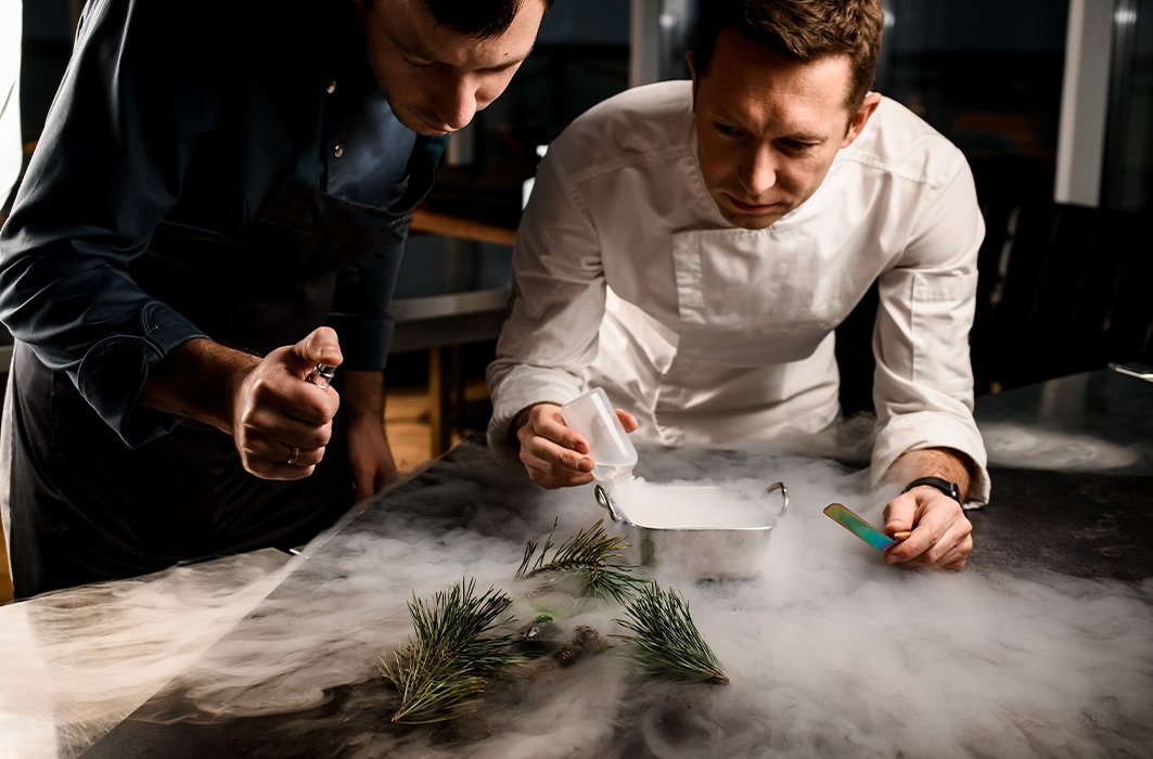 Deux personnes utilisent des techniques de cuisine moléculaire pour créer un repas. Deux personnes utilisent des techniques de cuisine moléculaire pour créer un repas.